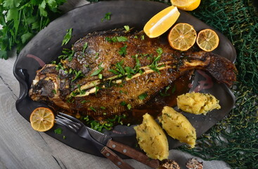 Two whole fresh flounder, butter, and lemon on black baking sheet  Sole Meuniere recipe