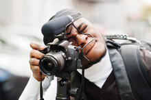 Young Professional African American Videographer Holding Professional Camera With Tripod Pro Equipment. Afro Cameraman Wearing Black Duraq Making A Videos.