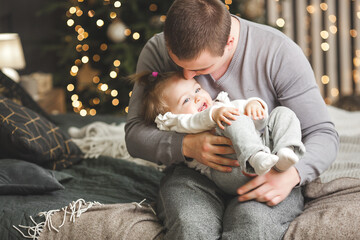 Wall Mural - Young father with his little baby girl on christmas background