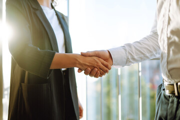 Handshake of colleagues. Business partners  in protective sterile mask shaking hands after contract meeting at customer office. Success teamwork, partnership and handshake. Covid-19.