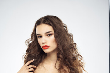 Wall Mural - woman with bare shoulders wavy hairstyle glamor makeup light background