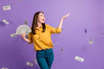 Canvas Print - Photo of young lady raise arm hold fan cash fall money wear yellow shirt blue pants isolated violet color background