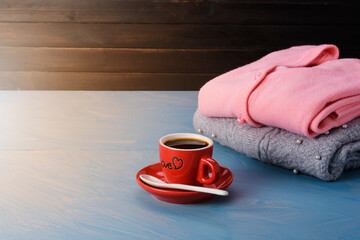 Wall Mural - Gray knit sweater Pink with coffee cup placed on a blue wooden table And a faint sunlight shone in Conceptual love and warmth