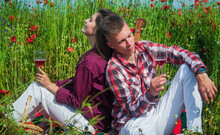 Romance. Romantic Relationship. Couple In Love Drink Wine. Man And Woman In Poppy Flower Field. Summer Vacation. Happy Family Among Red Flowers. Spring Nature Beauty. Bound Via Love
