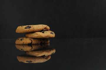 Canvas Print - chocolate homemade holiday cookies with chocolate drops are stacked on top of each other with a reflection side view of copy space