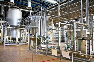 Production of beer: steel reservoirs and pipes in a brewery.