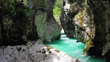 Static View Of Turquoise Water Of Soca River Flowing Through The Narrow Gorge Between Huge Rocky Mountains.