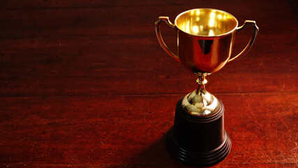 Wall Mural - gold trophy on wood table , winner concept.