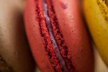 Poster - Colorful macaroons, delicious French pastries, stacked on wooden table.