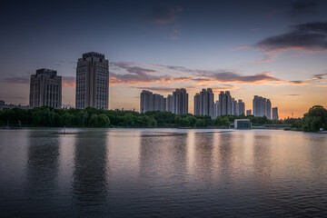 Wall Mural - Modern commercial building at sunset by the small lake