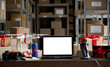 © insta_photos - Table with electronic devices and laptop computer mock up blank white on table, warehouse storage background. Ecommerce gadgets store website discount gifts. Black friday and cyber monday concept.