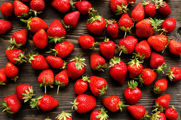 red raw fresh strawberries on wooden background, close view 