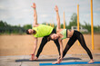 © Georgii - Workout of young couple in stylish sportswear outdoor on sports mats, healthy lifestyle