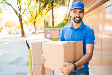 Delivery man carrying package outdoors.