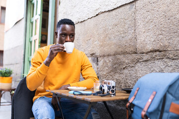 Wall Mural - Black Man Drinking Coffee in a Cafe.