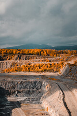 Wall Mural - A industrial lime stone quarry in the mountains with beautiful autumn colors on a wind dramatic day