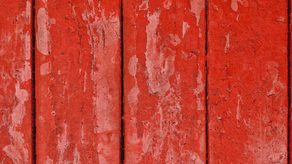  old wooden boards with red peeling paint with cracks. rough surface texture.
