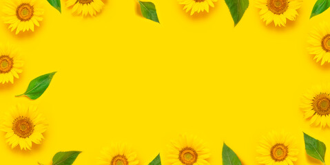 Fotomurales - Flower pattern. Frame of beautiful fresh sunflower with green leaves on yellow background. Flat lay top view copy space. Autumn or summer Concept harvest time agriculture. Sunflower natural background