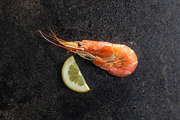 Wall Mural - Boiled tiger prawns on black table. Tasty shrimps.