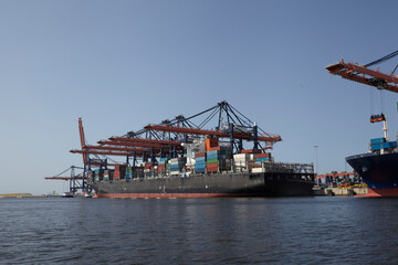 Large harbor cranes loading container ships in the port of Rotterdam.