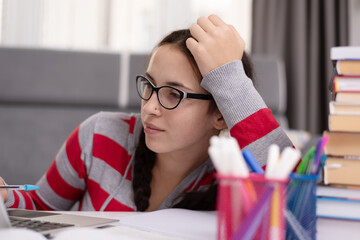 Social distancing student concept, education at home. High school girl doing homework at home with laptop. Teen study home the school is closed during Coronavirus Covid-19.