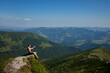 © volody10 - A girl sits on the edge of the cliff and looking at the sun valley and mountains