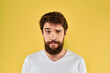 © SHOTPRIME STUDIO - A man in a white t-shirt gestures with his hands lifestyle cropped view yellow background more fun