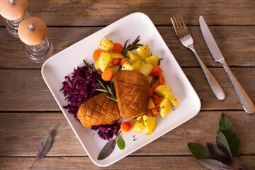 Wall Mural - Roast duck breast fillets with potatoes, carrots and red cabbage. View from above, top studio shot