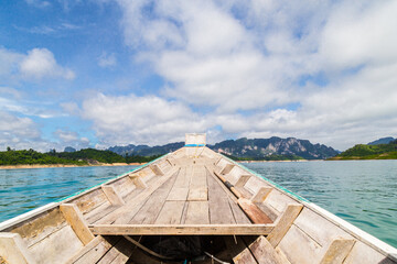 Wooden Thai traditional long-tail boat on a lake with mountains at Ratchaprapha Dam or Khao Sok National Park, Thailand