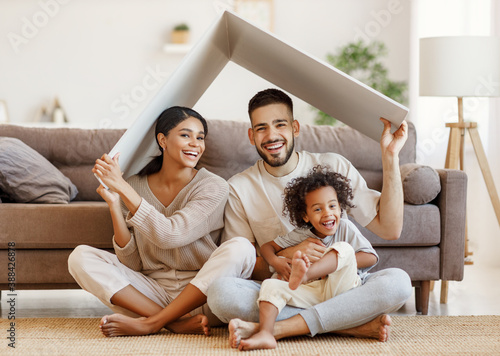 Happy family under fake roof in living room.