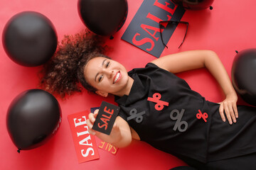 Sticker - Beautiful African-American woman with credit card and balloons on color background. Black Friday sale