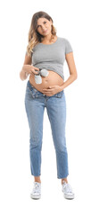 Wall Mural - Beautiful pregnant woman with baby shoes on white background