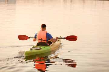 Wall Mural - Young man kayaking in river