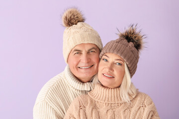 Poster - Mature couple in winter clothes on color background