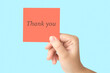 © Aleksey 159 - A female hand holds a paper note with the inscription thank you.
