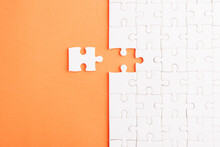 Top View Flat Lay Of Paper Plain White Jigsaw Puzzle Game Texture Last Pieces For Solve And Place, Studio Shot On An Orange Background, Quiz Calculation Concept