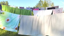 Colorful Laundry Hanging On The Rope Outdoors. The Process Of Air Drying Clothes