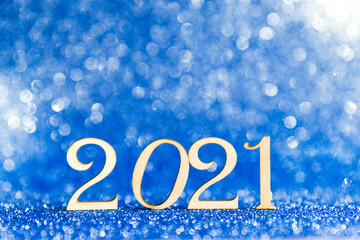 Numbers of new year 2021 on a blue shiny glitter background. Festive christmas background. Selective focus