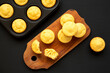 © Liudmyla - Homemade Cornbread Muffins on a rustic wooden board on a black surface, top view. Flat lay, overhead, from above.