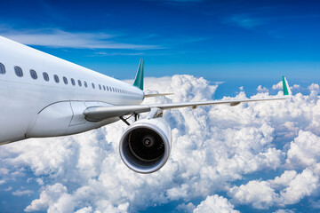 Wall Mural - Commercial airplane flying above blue sky and white clouds.