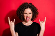 © deagreez - Photo of beautiful young girl tongue out hands show rock gesture isolated on vivid red color background