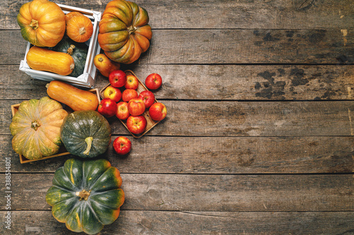 Fotografía Pile of red apples and pumpkins on wooden surface