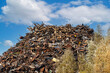 © ronstik - scrap metal heap at recycling junkyard against blue sky