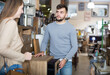 © JackF - Young man with girlfriend choosing vintage bedside table in furnishings store