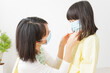 © maroke - 子供にマスクをつける保育士