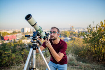 Wall Mural - amateur astronomer looking at the sky with a telescope.