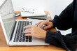 © Juli Puli - business composition. hands are typing the text behind the laptop. close-up of keyboard and hands