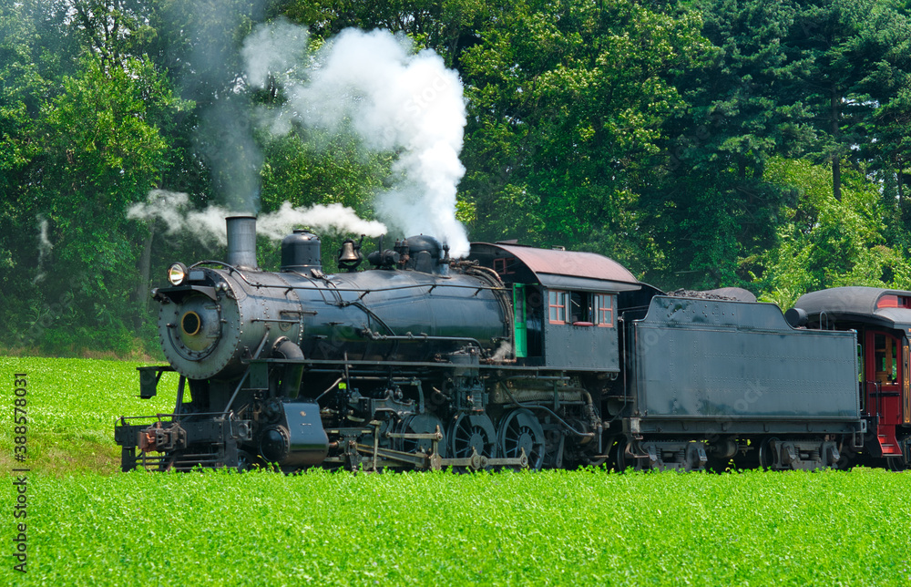 Close Up of an Antique Steam Passenger Train Puffing along Amish Countryside with Green Fields - obrazy, fototapety, plakaty 