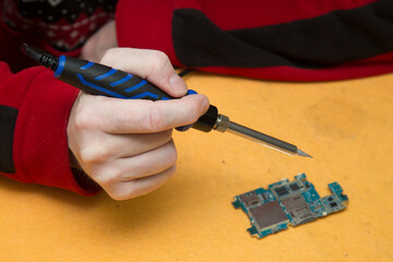 Wall Mural - Soldering iron for electronic boards. A tool for repairing electronic components.