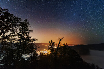 Wall Mural - a beautiful starry night in the mountains on top with beautiful scenery and fog.